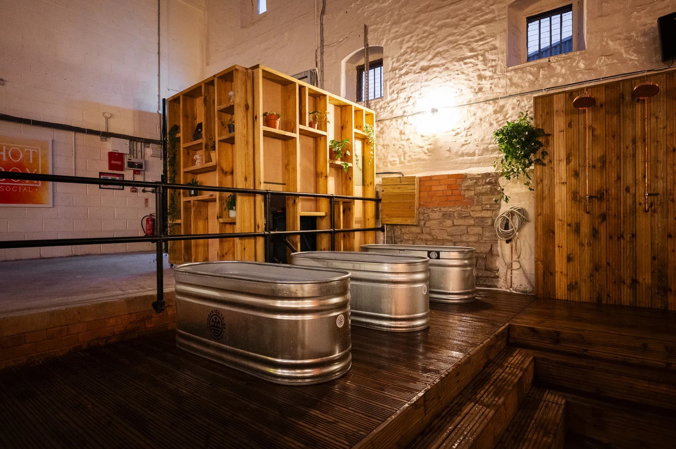Cold plunge pools beside the timber sauna entrance at HOTBOX Social